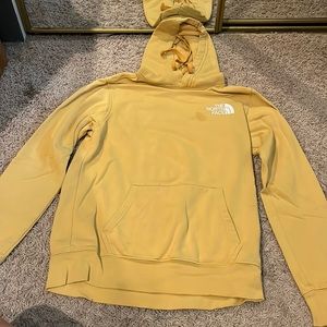 yellow north face hoodie, small stain near the north face symbol